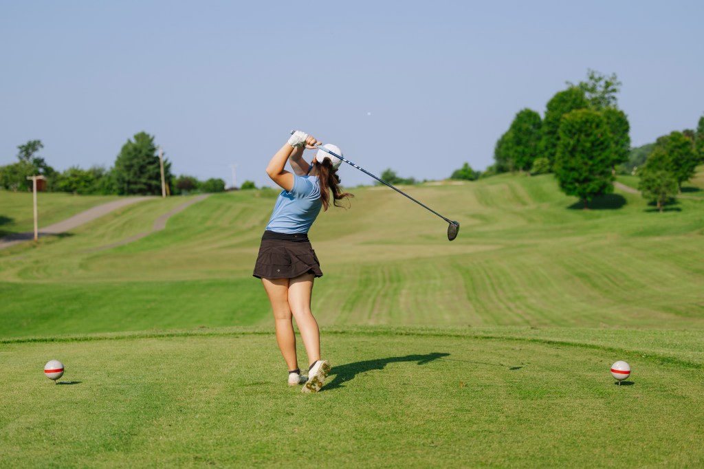Golfer taking a swing on green